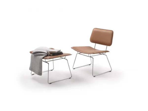 Le fauteuil Echoes S.H. de Flexform et le pouf de la même gamme.